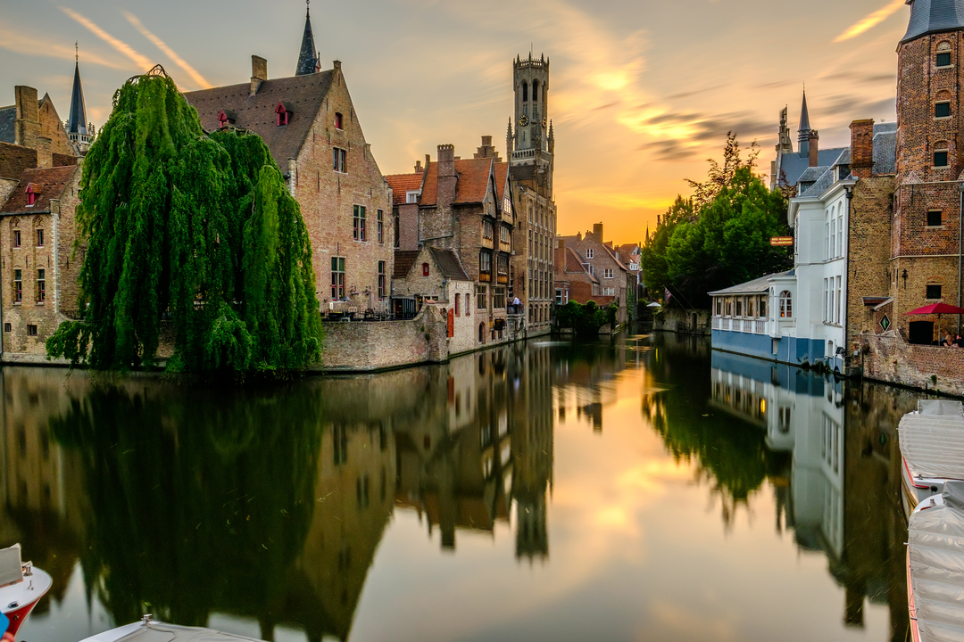 Bruges (Brugge) cityscape with water canal at sunset